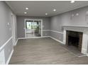 Spacious living room with updated flooring, neutral paint, and a stone fireplace at 3825 Old Coach Rd, Raleigh, NC 27616