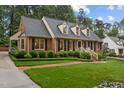 Brick home featuring landscaped grounds and mature trees at 3919 Wentworth Dr, Durham, NC 27707
