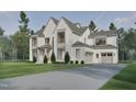 Beautiful two-story home boasts a gray driveway, white brick, attached garage, and immaculate landscaping at 413 Shinleaf Pond Trl, Raleigh, NC 27614