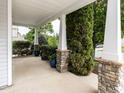 Inviting covered porch with stone columns and decorative plants, creating a cozy outdoor space at 4234 Offshore Dr, Raleigh, NC 27610