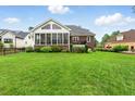 Expansive backyard with lush green lawn and inviting screened-in porch perfect for outdoor relaxation at 498 Mountain Laurel, Chapel Hill, NC 27517
