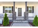 Inviting front porch with stone columns and a decorated front door entrance at 57 S Shreve Dr, Wendell, NC 27591