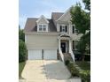 Traditional two-story home featuring a two-car garage, light siding, and manicured landscaping at 609 Redford Place Dr, Rolesville, NC 27571