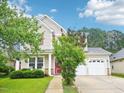 Attractive two-story home with a well-manicured lawn, a two-car garage, and a inviting front porch at 611 Ashbrittle Dr, Rolesville, NC 27571