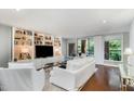 Bright living room features built-in bookshelves, a large TV, and a door to a balcony at 620 Martin Luther King Jr. Blvd # 302, Chapel Hill, NC 27514