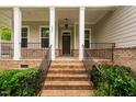 Inviting front porch with brick stairs, columns, and wrought iron railings at 623 Cabin Crk, Pittsboro, NC 27312