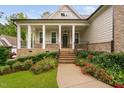 Inviting front porch with brick stairs, columns, and landscaped garden at 623 Cabin Crk, Pittsboro, NC 27312