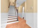 Entryway staircase featuring wooden steps and a classic white banister, complemented by neutral wall colors at 6423 New Market Way, Raleigh, NC 27615