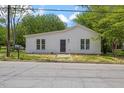 Charming one-story home with white siding, a dark front door, and a well-manicured front lawn at 714 Harriett St, Henderson, NC 27536
