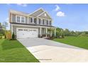 Charming two-story home with a large driveway and an attached two-car garage at 72 Merle Way, Wendell, NC 27591
