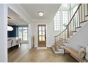 Beautiful foyer featuring light hardwood floors, elegant staircase, and plenty of natural light at 7736 Roberts Rd, Apex, NC 27523