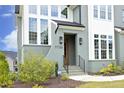 Home featuring an inviting front door with stylish lanterns, landscaped shrubs, and elegant brickwork at 7736 Roberts Rd, Apex, NC 27523