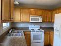 Bright kitchen featuring wooden cabinets, white appliances, and ample counter space at 78 Ariel Street, Lillington, NC 27546