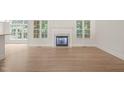 Bright living room with a fireplace, hardwood floors, and large windows overlooking the garden at 85 Pebble Creek Dr, Franklinton, NC 27525
