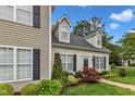 Exterior showing the light-colored siding, landscaping, black shutters, dormer windows and greenery at 8611 London Park Ct, Raleigh, NC 27615