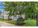Exterior shot showcasing the well-maintained lawn and front of the townhome with black shutters at 8611 London Park Ct, Raleigh, NC 27615