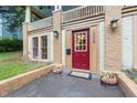 Close-up of a red front door with house number, enhanced by sidelights and potted plants at 1008 Dorothea Dr, Raleigh, NC 27603