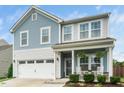 Inviting two-story home with a classic facade, front porch, and well-manicured landscaping at 102 Michelangelo Pl, Morrisville, NC 27560