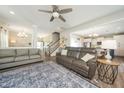 Open concept living room featuring a cozy couch, area rug, and a view of the kitchen and staircase at 102 Michelangelo Pl, Morrisville, NC 27560