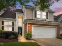 Charming two-story home with a two-car garage, brick accents, and lovely sunset at 103 Lake Tillery Dr, Cary, NC 27519