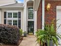 Inviting home entrance with a tall entry door and red brick accents at 103 Lake Tillery Dr, Cary, NC 27519