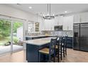 Bright kitchen with a large island, white quartz countertops, and stainless-steel appliances at 103 Lake Tillery Dr, Cary, NC 27519