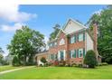 Beautiful brick home with lush lawn, mature trees, and a welcoming green front door at 103 Rose Sky Ct, Cary, NC 27513