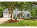 Inviting two-story home with well-manicured lawn and mature tree offering shade and curb appeal at 106 Fawley Ct, Cary, NC 27519
