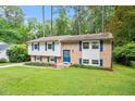 Charming two-story home featuring a mix of brick and siding, complemented by vibrant blue shutters and a well-manicured lawn at 1109 Buckingham Rd, Garner, NC 27529