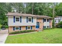 Charming split-level home featuring a brick facade, well-manicured lawn, and mature trees at 1109 Buckingham Rd, Garner, NC 27529