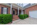 Inviting front entrance with brick steps and manicured greenery leading to the home at 119 Georgetowne Dr, Elon, NC 27244