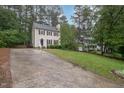 Classic two-story home with a neutral exterior, black shutters, and a spacious driveway leading to the residence at 12 Striding Ridge Ct, Durham, NC 27713