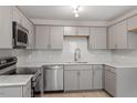 Beautiful kitchen featuring gray cabinets, stainless steel appliances, subway tile backsplash, and quartz countertops at 1211 Freeman Dr, Sanford, NC 27330