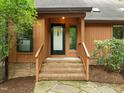 Inviting home entrance featuring a brick porch, wooden railings, and a storm door at 122 Blackcherry Ln, Chapel Hill, NC 27514