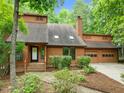 Traditional brown home featuring a two-car garage, green shrubs, and a stone path at 122 Blackcherry Ln, Chapel Hill, NC 27514
