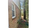 Side exterior of a brick home with a window and utility connections visible at 1310 Ray Ave, Sanford, NC 27330