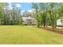 Landscaped front lawn leading to a charming two-story home nestled among mature trees at 1508 Banks Brooke Dr, Raleigh, NC 27603