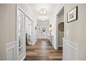 Inviting hallway featuring wood floors, panel molding, and stylish decor, leading to various rooms at 1533 Santa Lucia St, Wake Forest, NC 27587