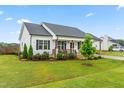 Stylish single-story home with a well-kept lawn, covered porch, and attached carport at 173 Longbow Dr, Middlesex, NC 27557