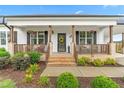 Inviting front porch with brick steps, charming columns, and colorful flower accents at 173 Longbow Dr, Middlesex, NC 27557