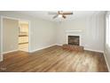Inviting living room featuring hardwood floors, a fireplace, and a ceiling fan, perfect for relaxation at 2012 Stadium Dr, Durham, NC 27705