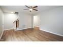 Spacious living area with hardwood floors, ceiling fan, and staircase access to upper levels at 2012 Stadium Dr, Durham, NC 27705