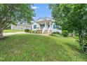 Well-maintained single-story home featuring a manicured lawn, accented by lush trees and an inviting porch at 202 Homestead Park Dr, Apex, NC 27502