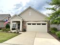 Charming single-Gathering home featuring a stone accent facade, two-car garage and well-manicured lawn at 228 Ellisview Dr, Cary, NC 27519