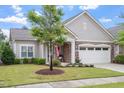 Charming home featuring stone accents, a covered porch, manicured lawn, and an attached two-car garage at 228 Ellisview Dr, Cary, NC 27519