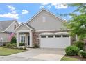 Charming home featuring stone accents, a covered porch, manicured lawn, and an attached two-car garage at 228 Ellisview Dr, Cary, NC 27519