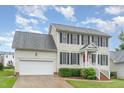 Two-story home with an attached garage, black shutters, a red front door, and a landscaped lawn at 2301 Laurel Valley Way, Raleigh, NC 27604