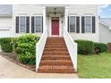 Front steps leading to a red front door with lush landscaping and white railing at 2301 Laurel Valley Way, Raleigh, NC 27604