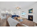 Bright living room featuring a leather sectional sofa, fireplace, and open floor plan flowing into the kitchen at 247 Axis Deer Ln, Garner, NC 27529