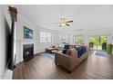 Spacious living room with a cozy fireplace, plush leather sofa, and sliding glass doors to the backyard at 247 Axis Deer Ln, Garner, NC 27529